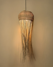 Tall jellyfish-inspired pendant light with woven top and flowing raffia strands 