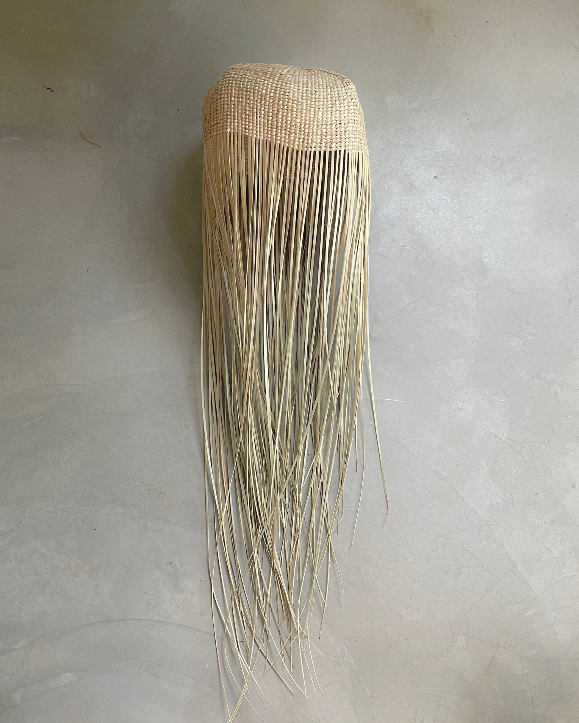 Tall jellyfish-inspired pendant light with woven top and flowing raffia strands, handmade and customisable lighting
