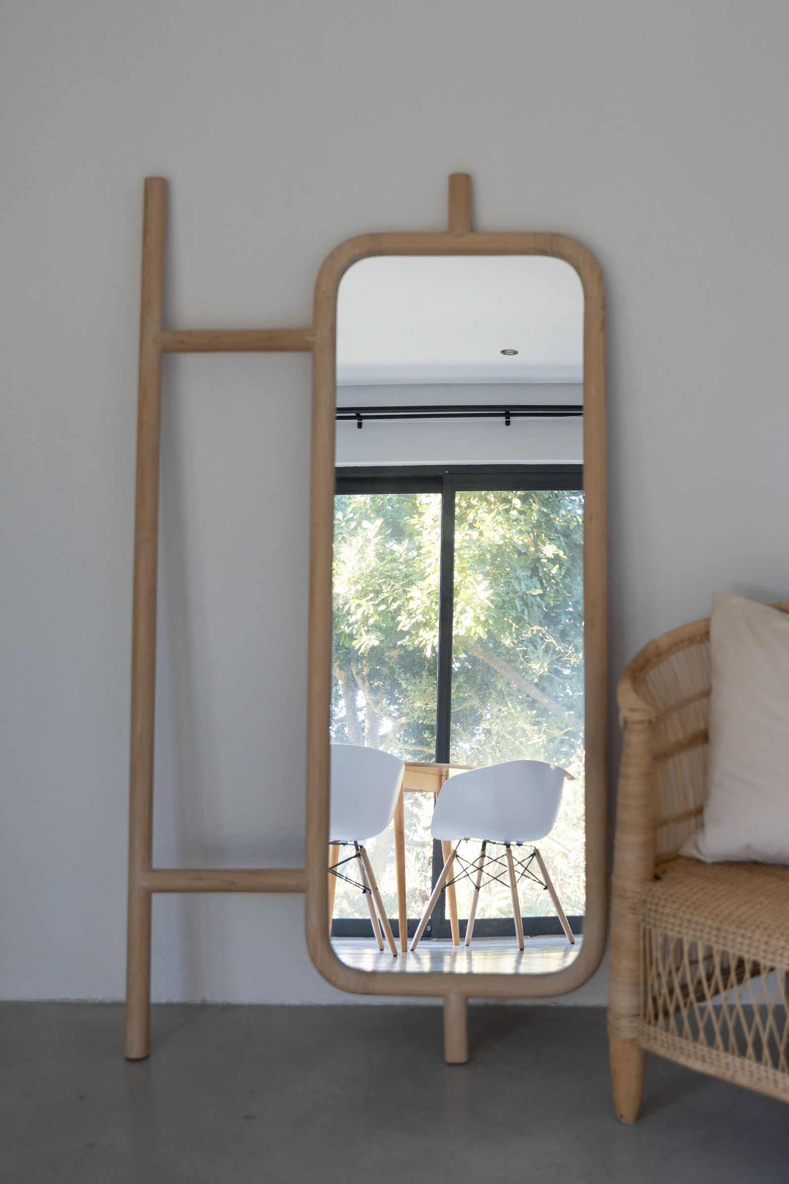 Wooden floor mirror leaning against a wall.