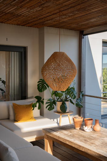 Living room with a wicker pendant light, woven decorative items on stainlees steel suitable for outdoor environments
