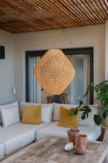 Living room with a wicker pendant light, woven decorative items.
