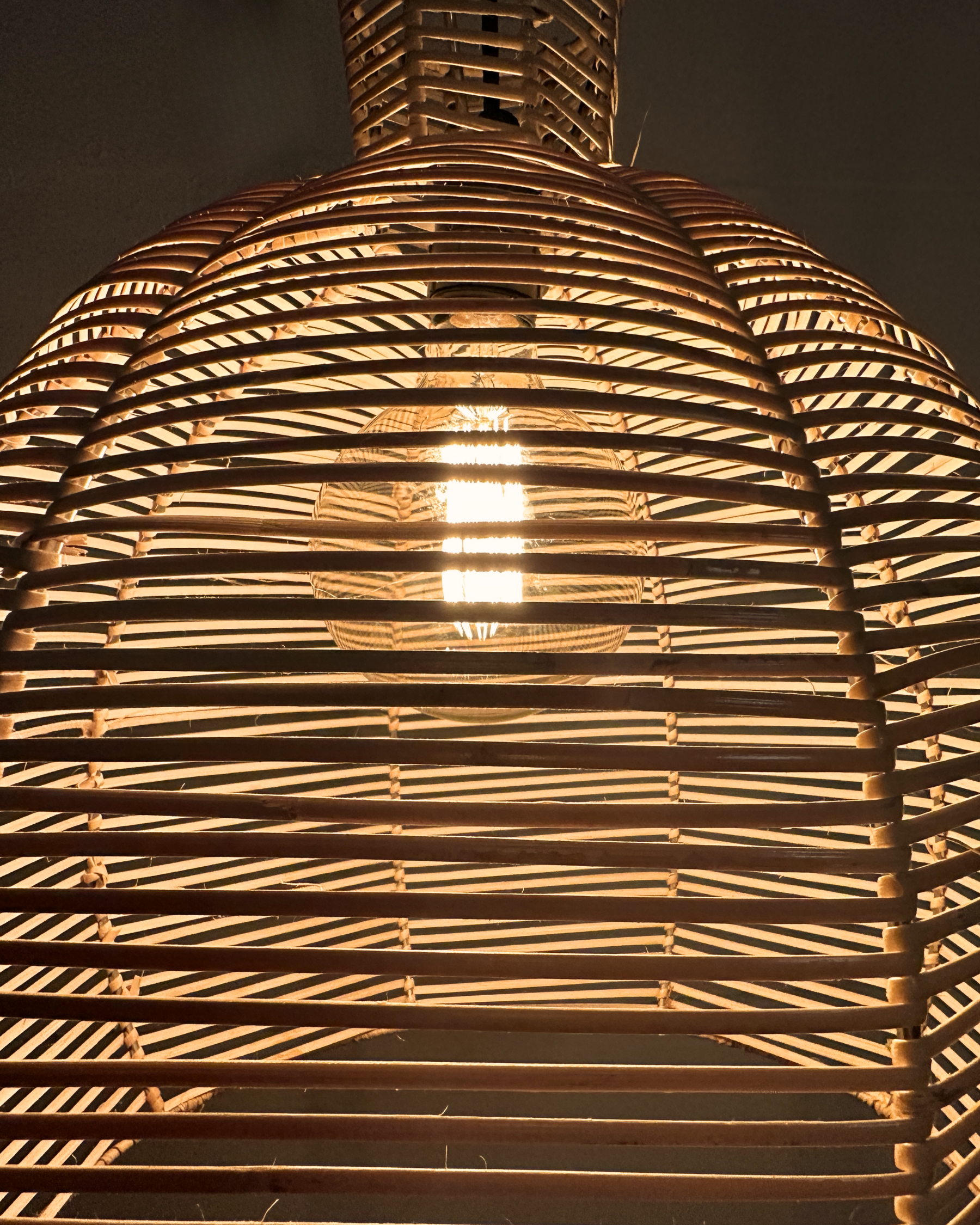 A ceiling-mounted chandelier with a stainless steel frame and tightly hand woven bamboo cane strips, creating a warm, ambient light. All locally made, all customisable lighting.
