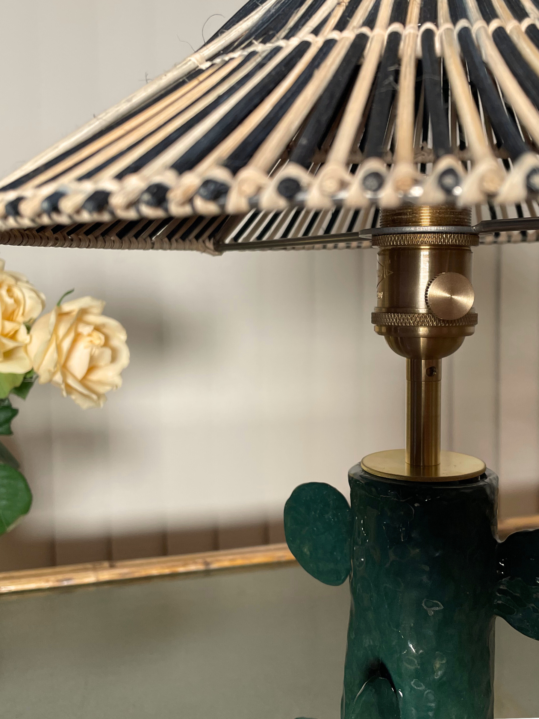 Decorative lamp with a green base and black and white striped shade.