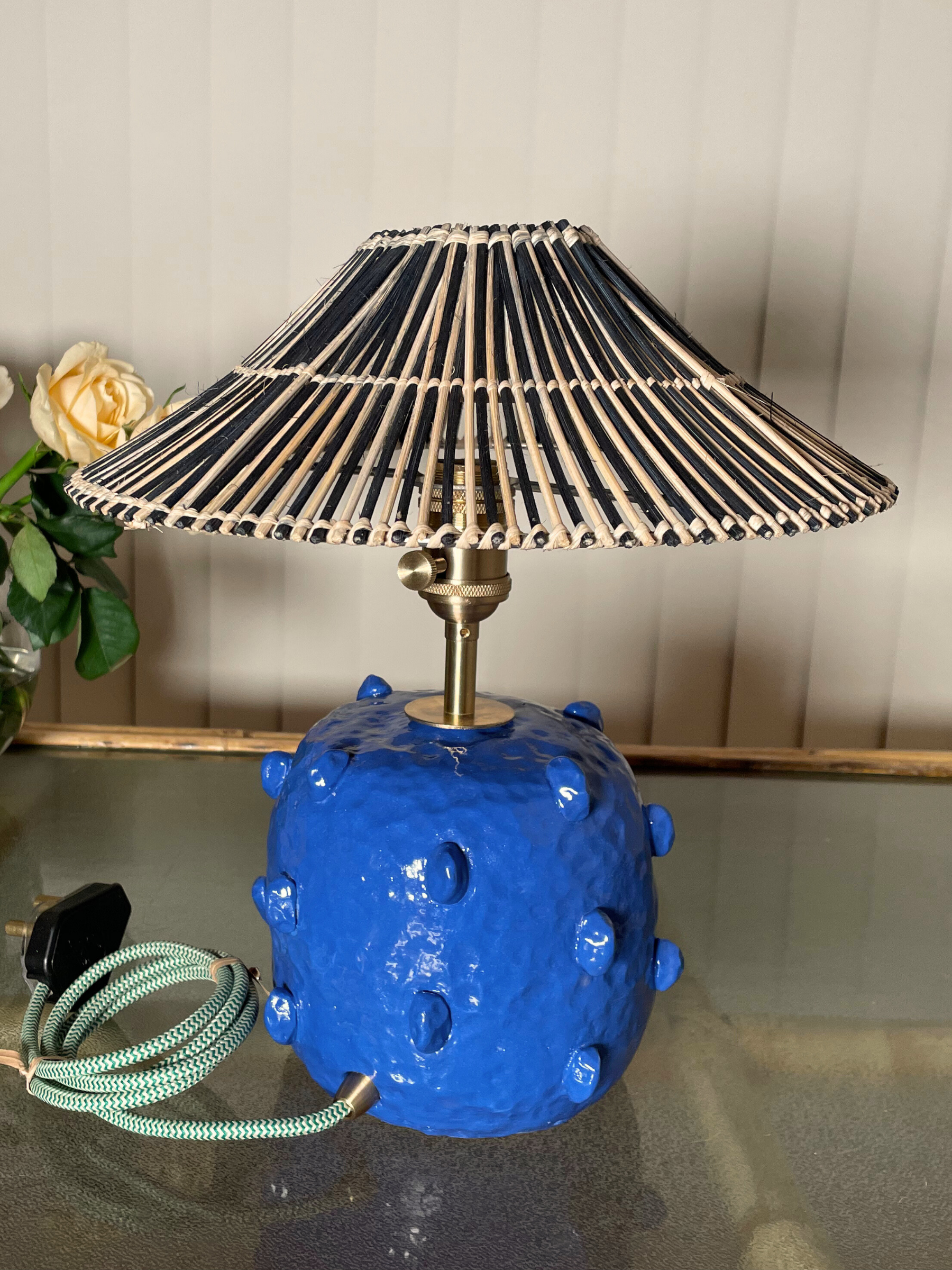 Blue textured lamp with a black and gold striped shade