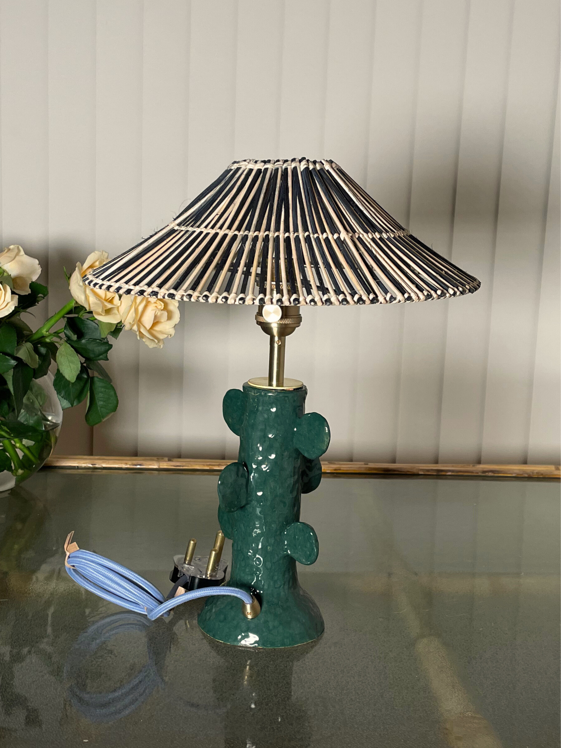 Green table lamp with a pleated black and white shade 