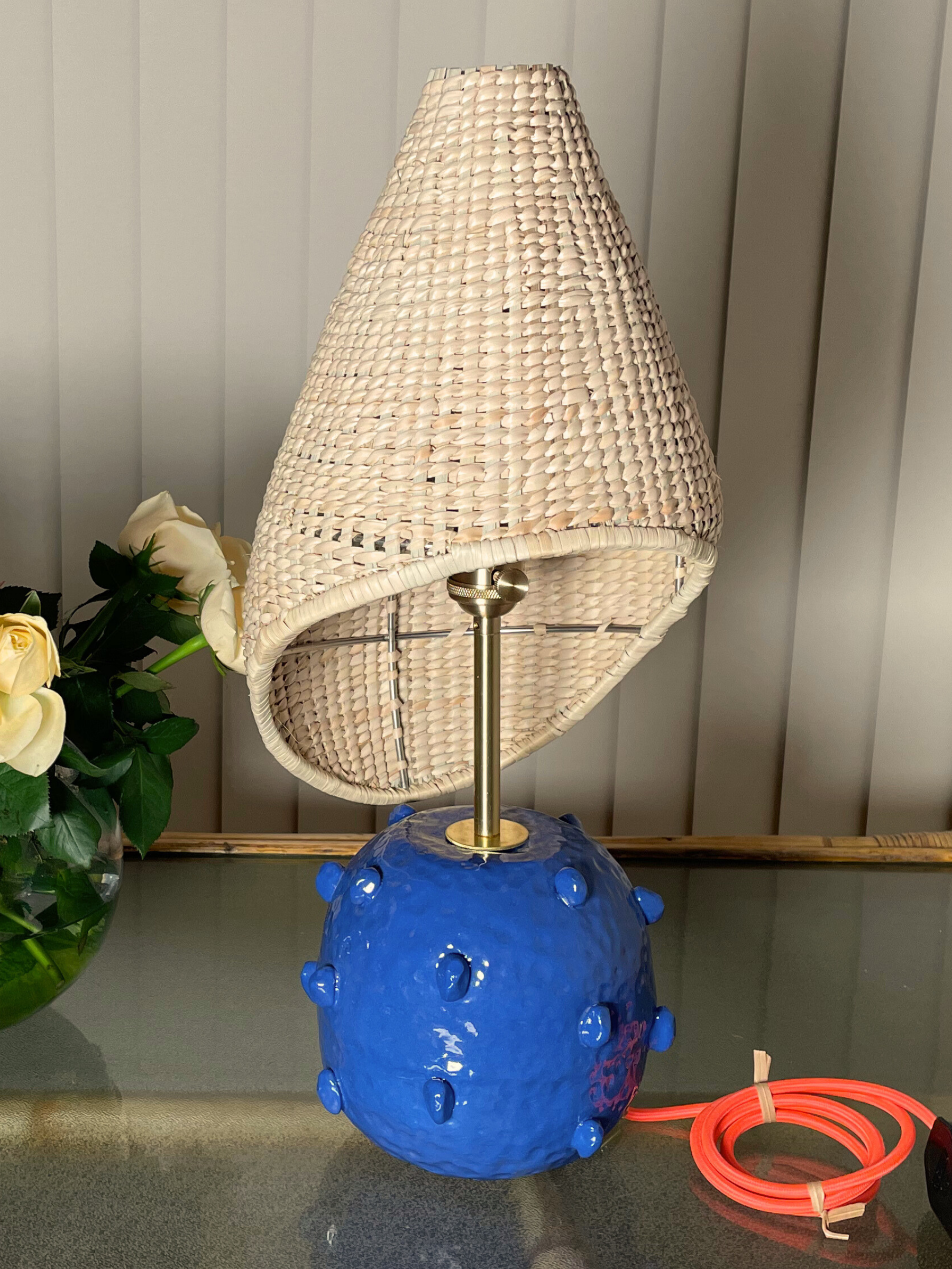 Table lamp with wicker shade and blue base brass fixtures