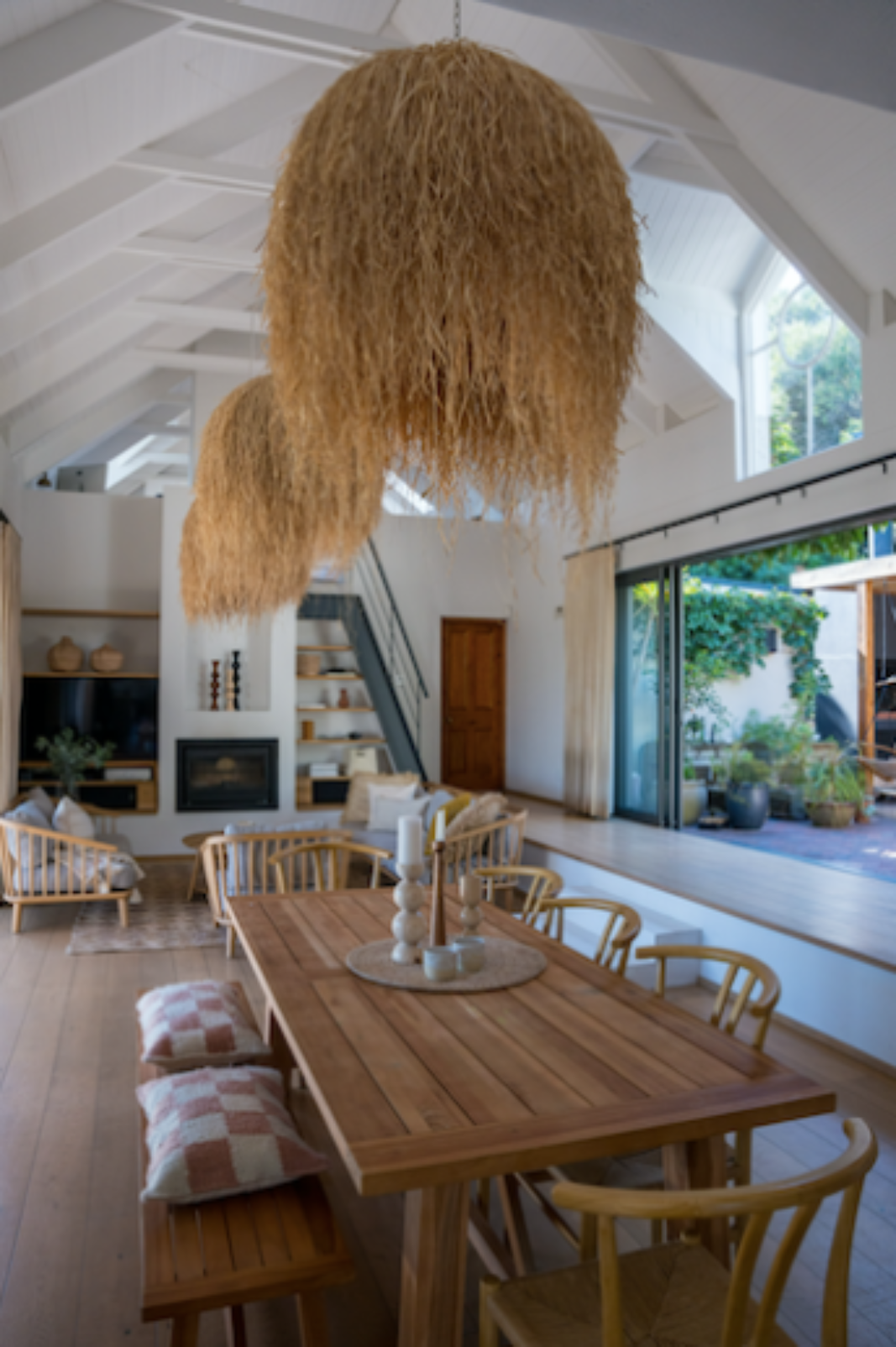 Dining area with wooden candle holders, woven lampshade pendant light.
