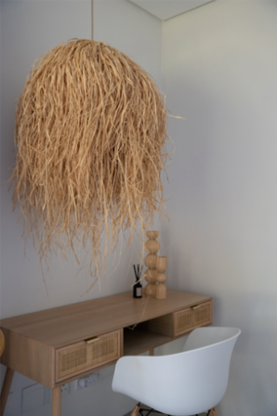 Beige pendant light hanging above a wooden candle holders