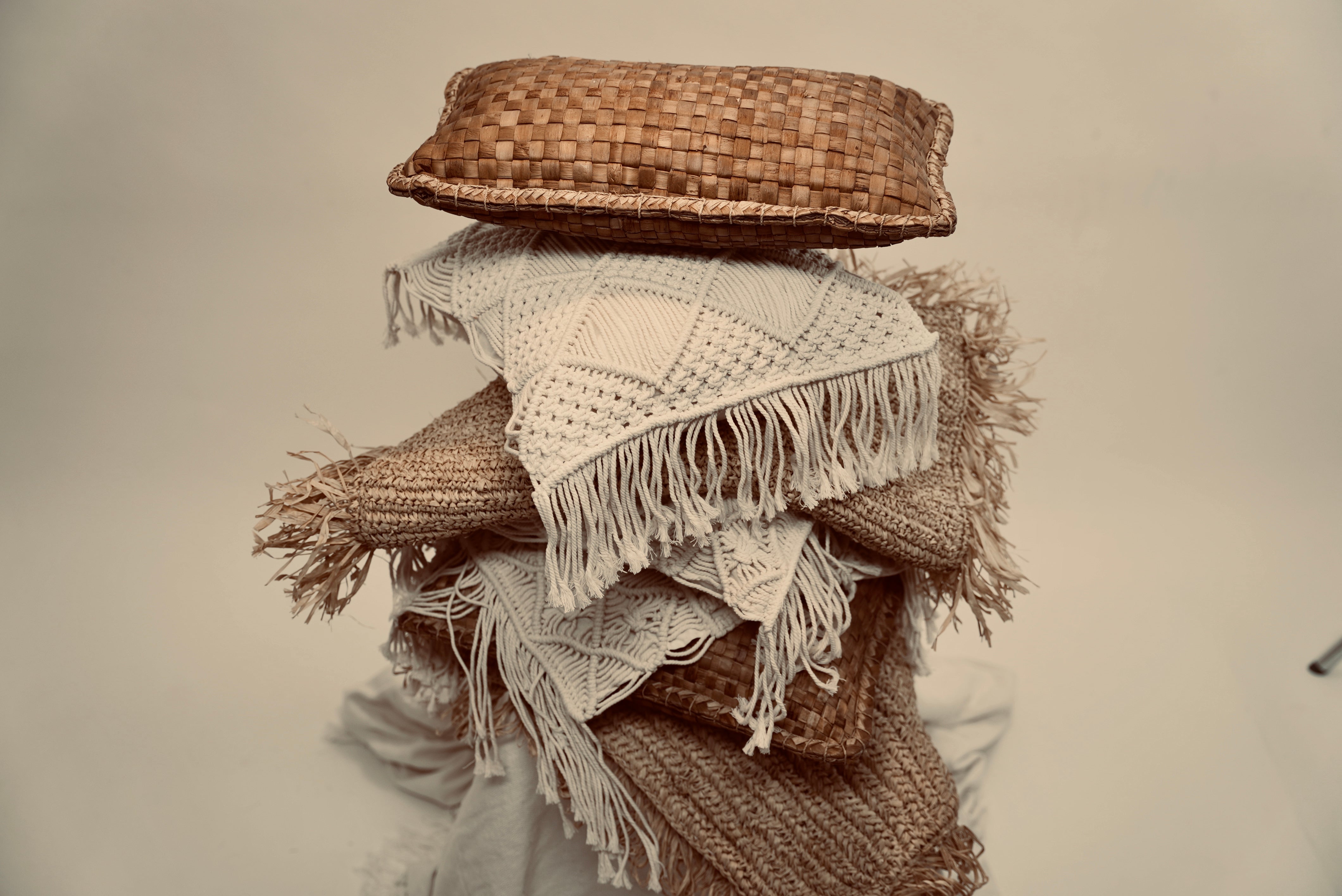 A stacked heap of cushions consisting of the Raffia cushion cover and our crispy woven cover as well