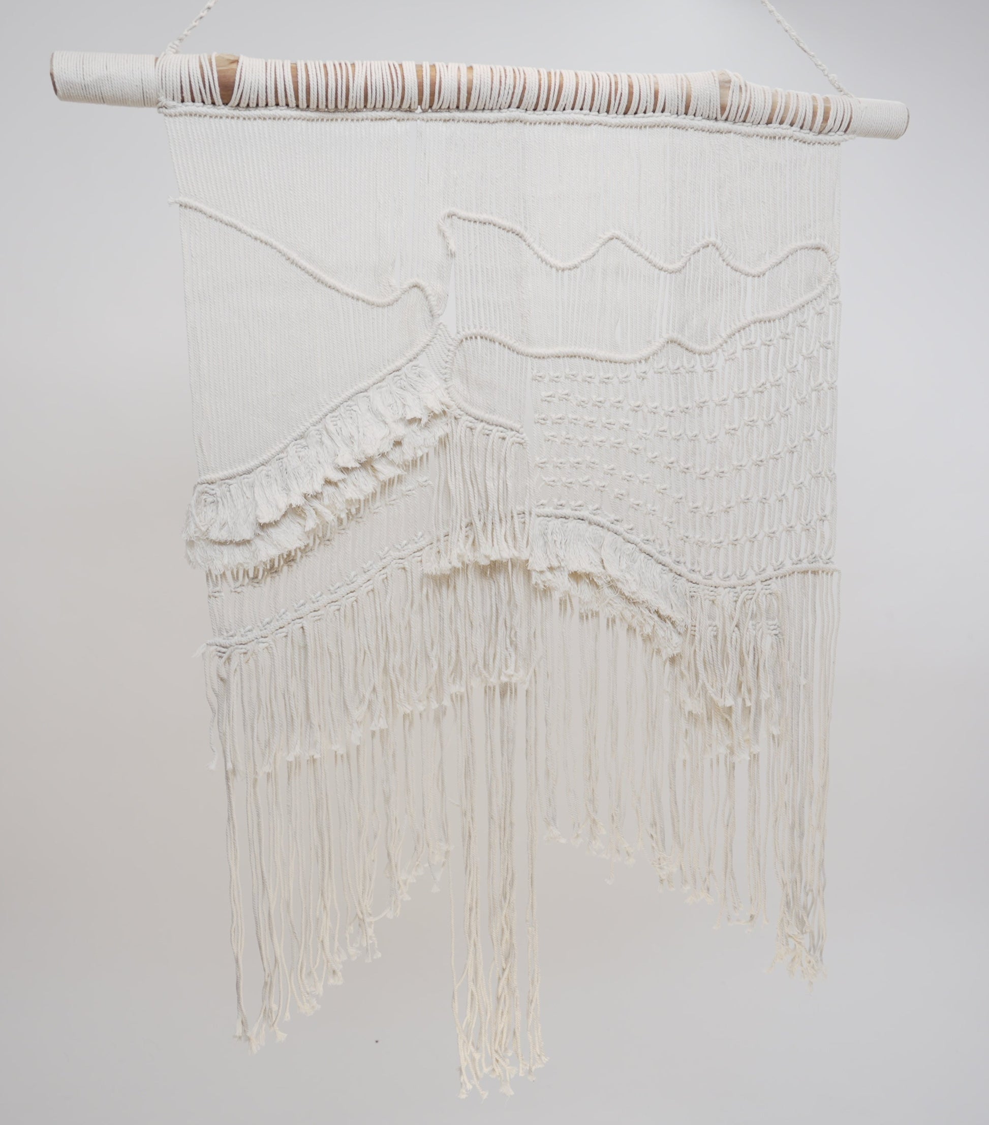 The macrame wall hanger photographed against a neutral background