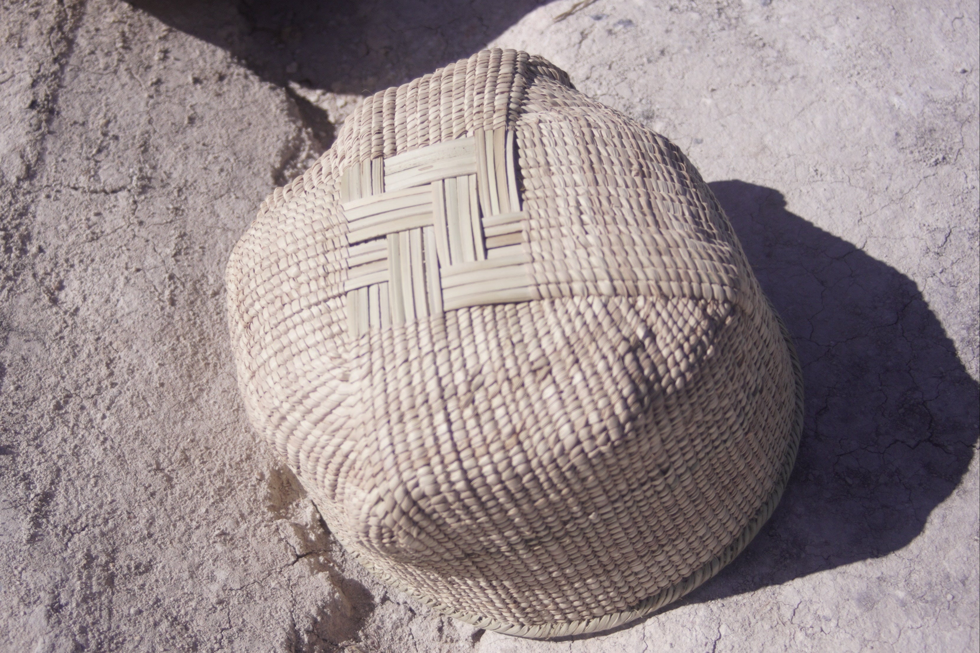 Ilala wonky basket photgraphed from the bottom and shows cross shaped woven pattern