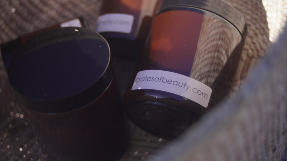 Close-up of soy candles in amber glass jars photographed in our woven wonky basket