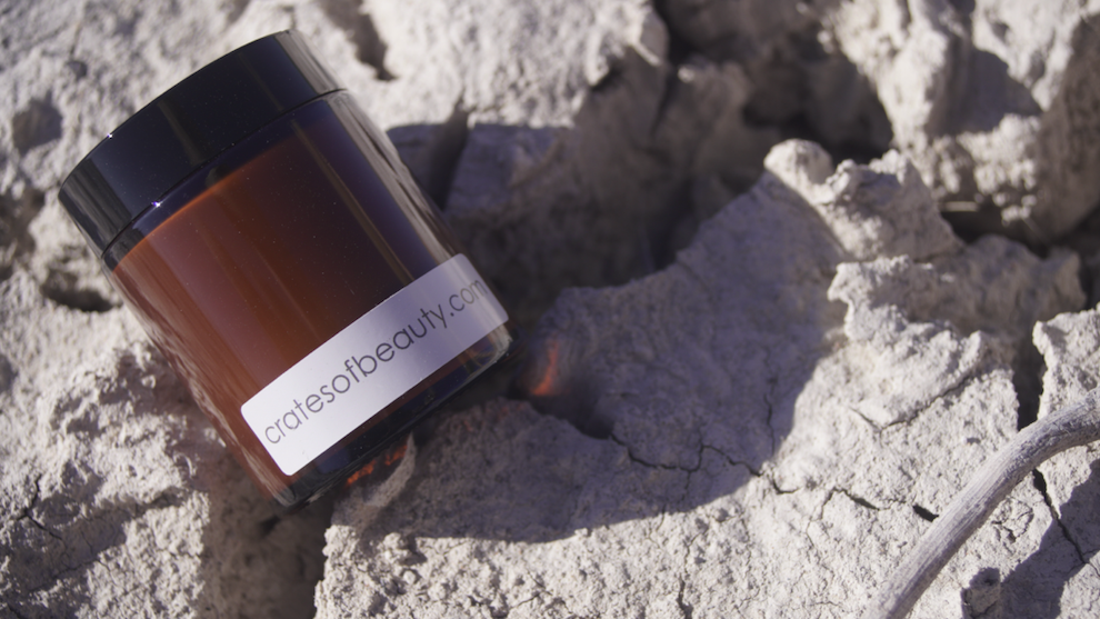 Close-up of soy candles in amber glass jars  