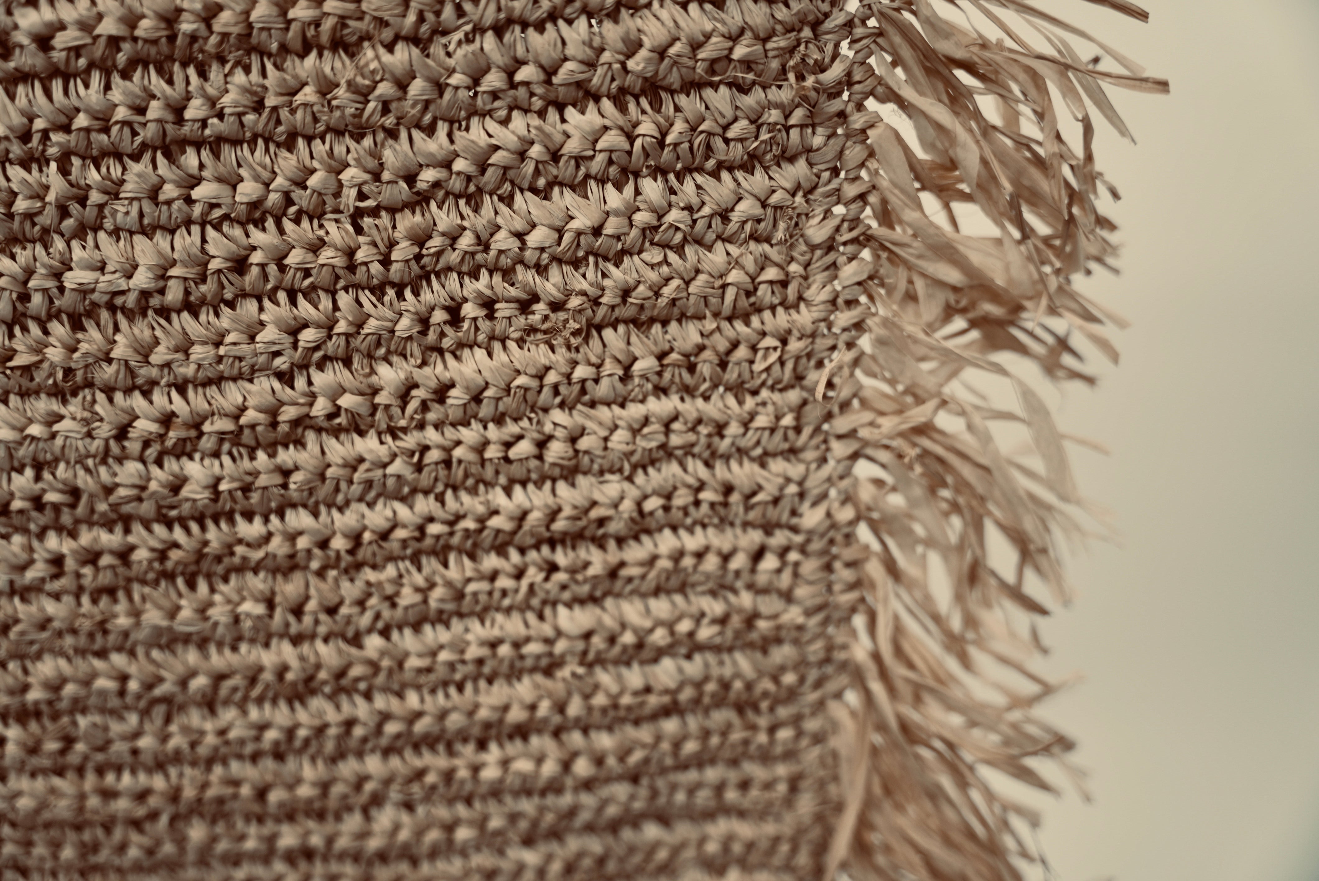A close-up of the Raffia cushion cover showcasing hand woven detail