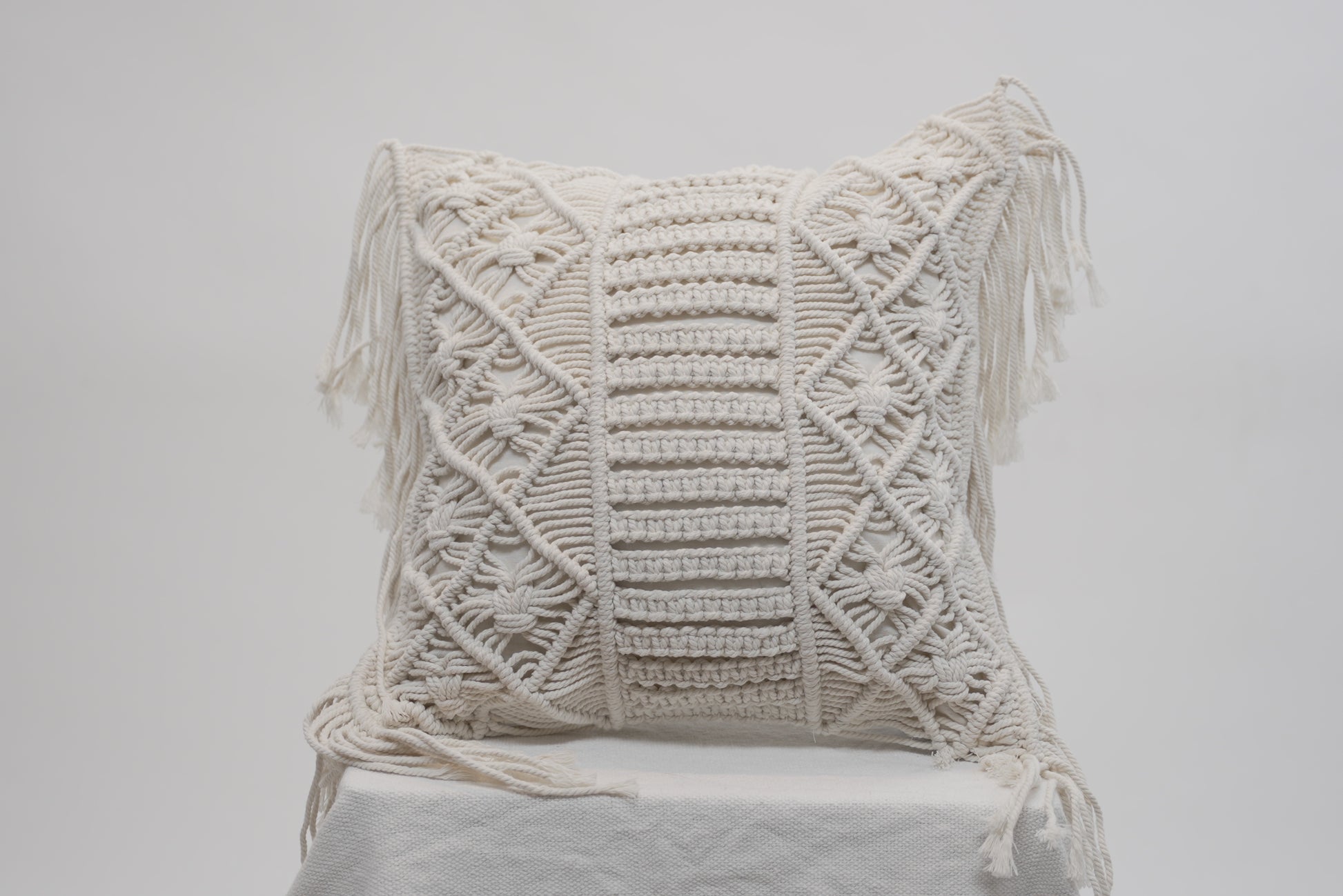 The macrame scatter cushion with side tassles for beach inspired luxury homes