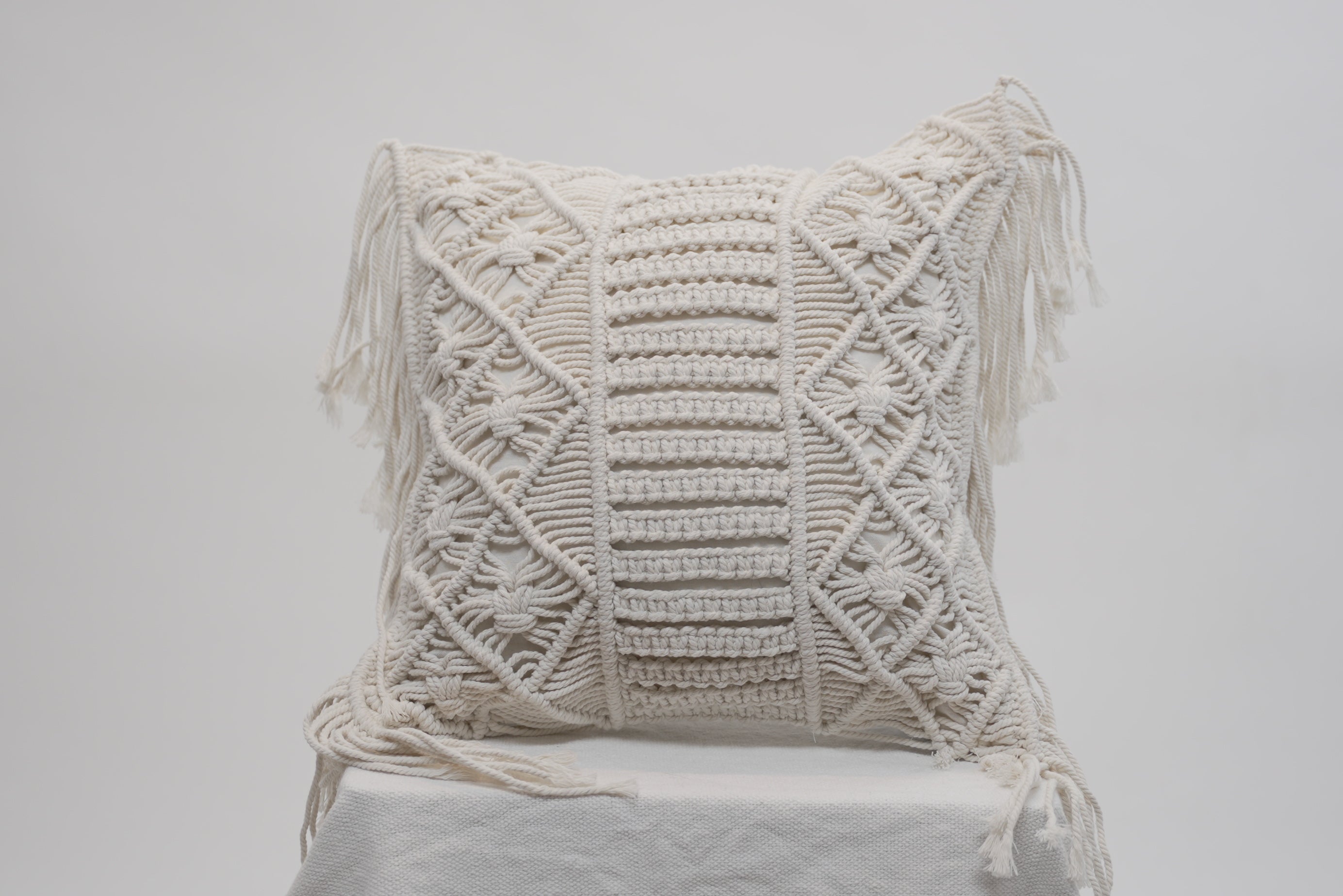 The macrame scatter cushion with side tassles for beach inspired luxury homes