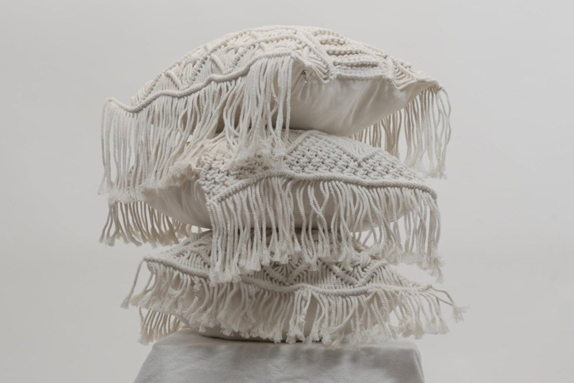 The macrame scatter cushions stacked on each other different variants